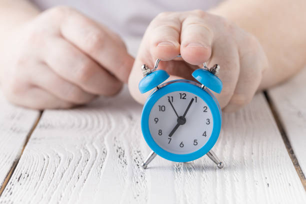 istock Man hold and shocked with late alarm clock 1221479547