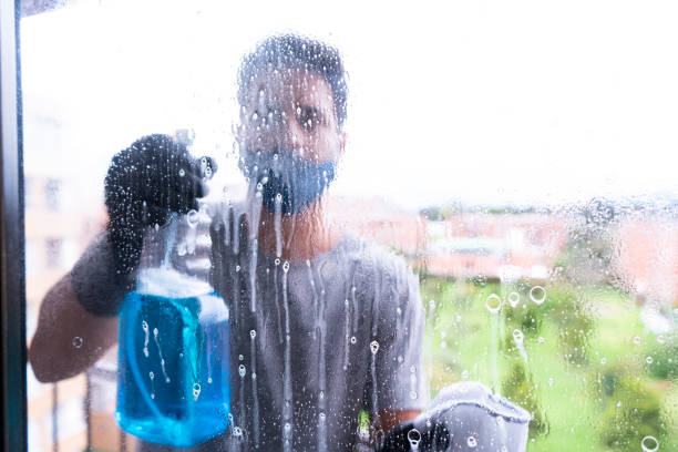 istock Latino man cleans the windows of his balcony 1221480130
