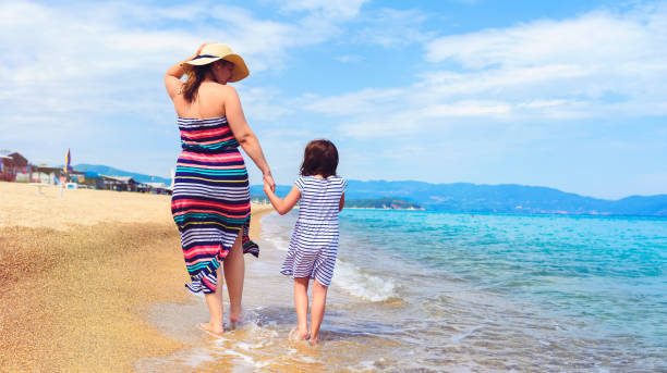 istock Mother And Little Daughter Walking Along Tropical Beach 1221480767