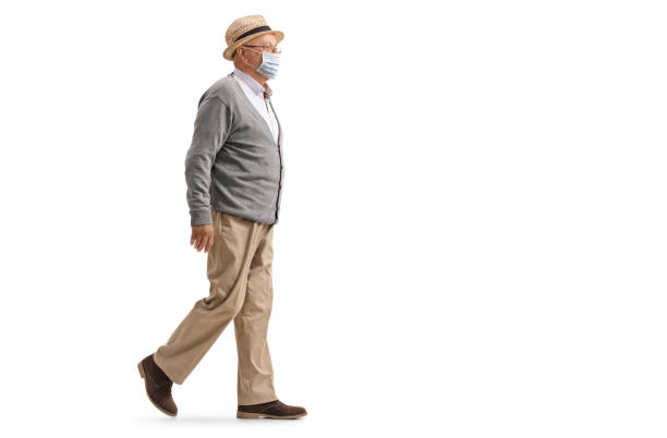 istock Eldelry man walking and wearing a protective medical face mask 1221480951