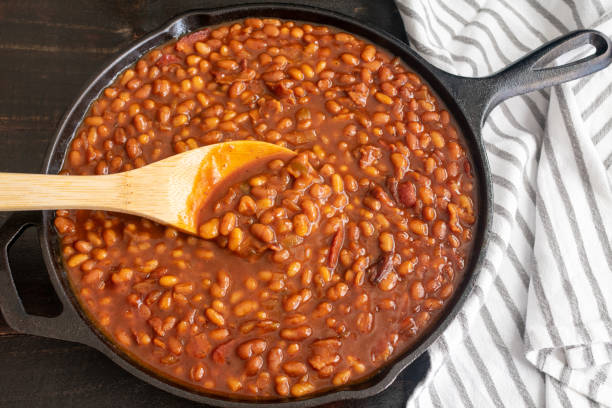 Bourbon Baked Beans in a Cast Iron Skillet Pork and beans seasoned with bourbon whiskey, molasses, and brown sugar baked beans stock pictures, royalty-free photos & images