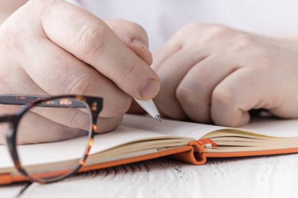 istock Close up hand of student writing notes in to notebook 1221482653