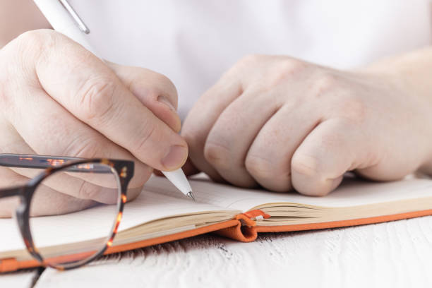 istock Close up hand of student writing notes in to notebook 1221482678
