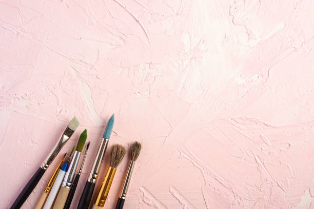 istock Paint brushes, artist tools for drawing on textured pink background, top view, copy space 1221484032