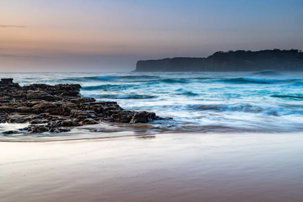 Coastal Sunrise Seascape with Beach and Rock Platform Sunrise Seascape from the North Avoca Beach rock platofrm on the Central Coast, NSW, Australia. avoca beach photos stock pictures, royalty-free photos & images