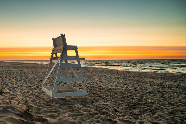 An empty lifeguard stand looks out over the ocean at sunrise at Beach Haven, NJ stock photo