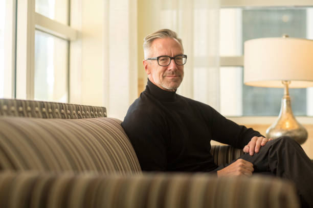 istock Portarit of a handsome older man sitting on a sofa 1221487584