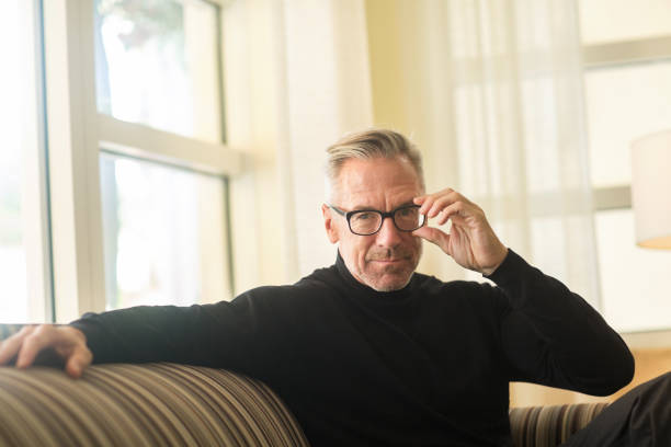 istock Portarit of a handsome older man sitting on a sofa 1221487618