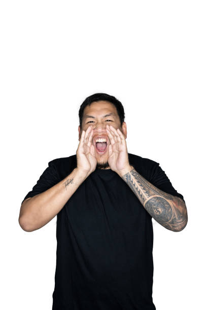 istock Bearded asian men worker dressed in black tees is shouting with two hands in white background.The concept of protest, attention, request. Place for text or copy space.clipping path. 1221489089