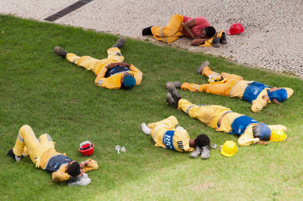Workers Relaxing During Working Break Rio de Janeiro, Brazil - January 13, 2016: Municipal workers relaxing during lunch break time. lazy construction laborer stock pictures, royalty-free photos & images