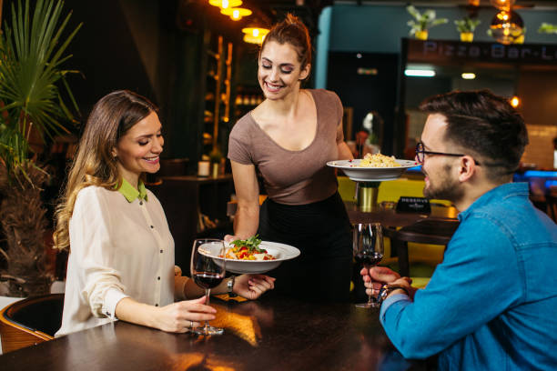 istock Young waitress serving young couple at the restaurant 1221493869