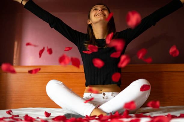 istock Woman throwing rose petals on the bed. 1221497882