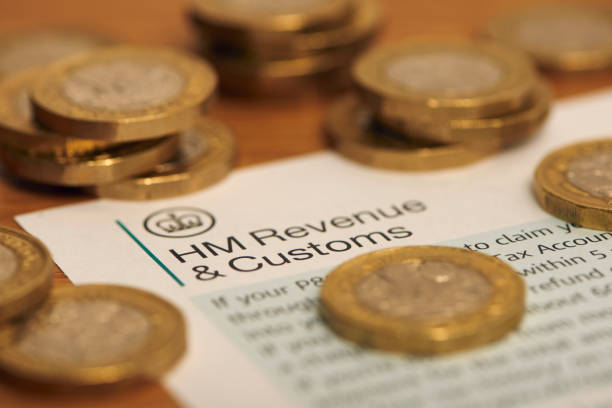 HMRC and money English money surrounding a HMRC letter head one pound coin photos stock pictures, royalty-free photos & images