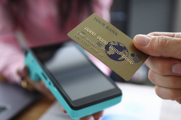 istock Man holds credit card with PayPass technology 1221500850