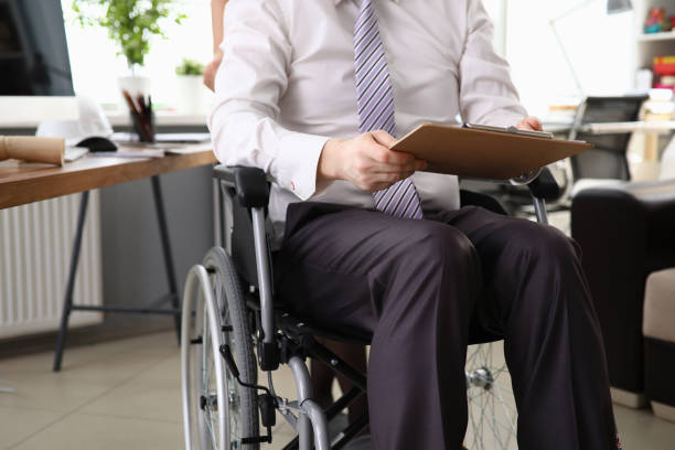 istock Employee man working in an office on wheelchair 1221500853