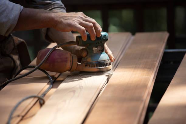 istock Man sanding redwood planks outdoors with orbital sander 1221501323