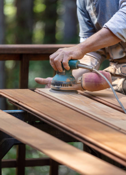 istock Man sanding redwood planks outdoors with orbital sander 1221501370