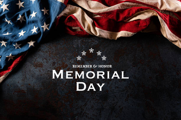 istock Happy Memorial Day. American flags with the text REMEMBER & HONOR against a black stone texture background. May 25. 1221504112