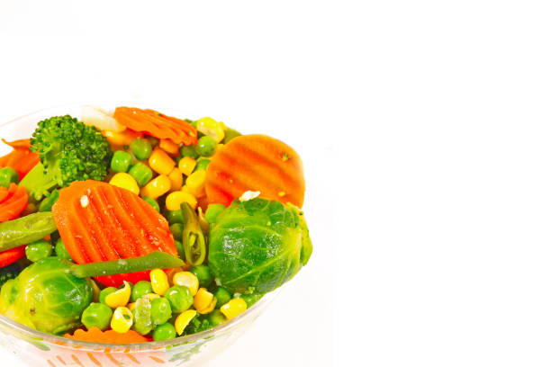 Frozen vegetables in a glass bowl on a white background
