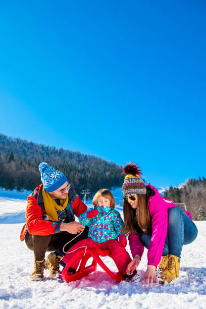 istock Happy Family In Snow Riding On Sledge. 1221504532
