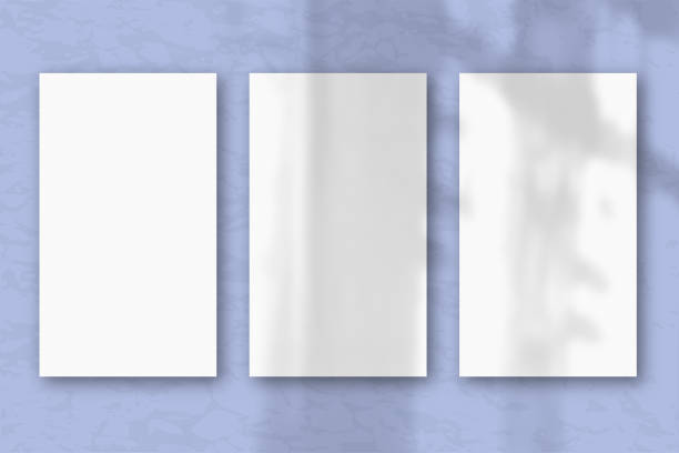 istock 3 vertical sheets of textured white paper on soft blue table background, natural light casts shadows from the window. Horizontal orientation 1221506922