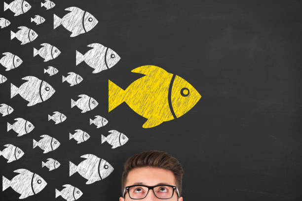 istock Leadership Concepts with Fishes on Chalkboard Background 1221507786