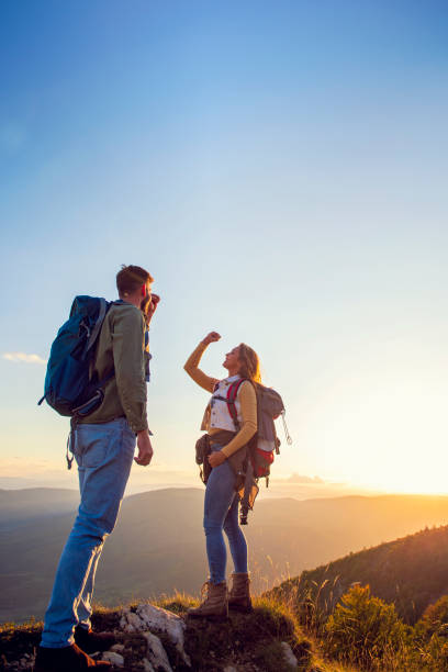 istock Couple on Top of a Mountain Shaking Raised Hands 1221507815