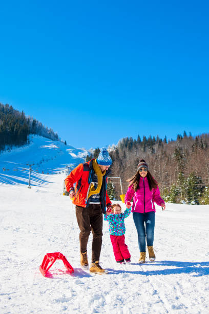istock Happy Family In Snow Riding On Sledge. 1221508995