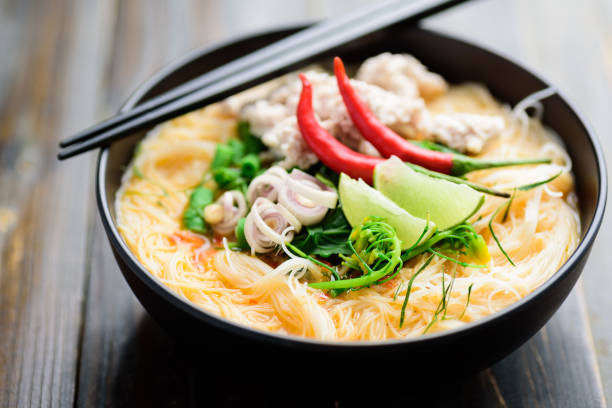 spicy rice noodles soup with spices and herbs (thai tom yum) - sopa tom yum imagens e fotografias de stock