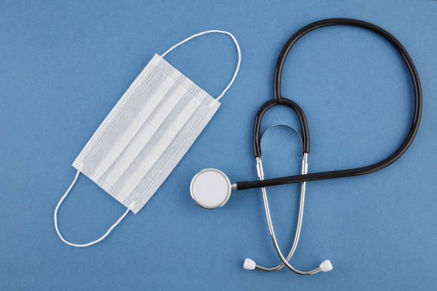 istock Stethoscope on a Blue background and face mask 1221511342