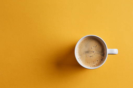 Cup of coffee on yellow background like switch button