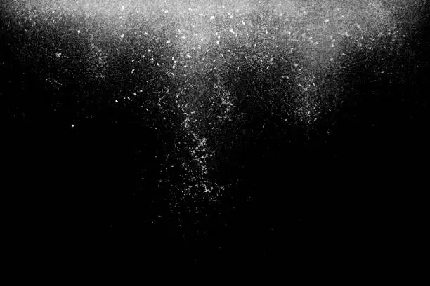 Freeze motion of white star powder falling, isolated on black, dark background. Abstract design of white dust cloud. Particles explosion screen saver, wallpaper with copyspace. Planet creation concept