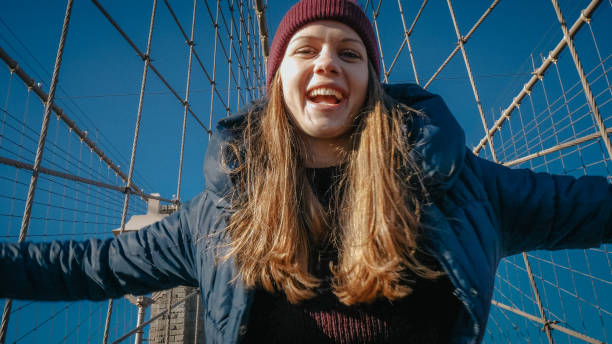 młoda szczęśliwa kobieta na brooklyn bridge w nowym jorku - large transportation bridge famous place zdjęcia i obrazy z banku zdjęć