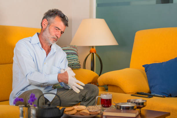 uomo che indossa guanti medici per bere una tazza di tè - housebound foto e immagini stock