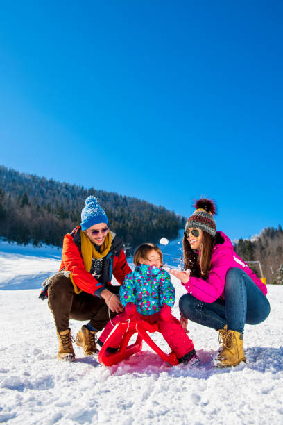 istock Happy Family In Snow Riding On Sledge. 1221521365
