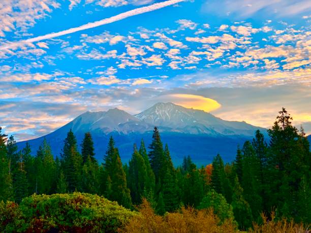 Mount Shasta, CA Sunrise behind Mount Shasta and a lenticular cloud in early fall. mt shasta stock pictures, royalty-free photos & images