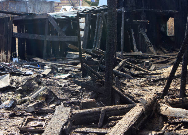 istock After fire - burnt house. Black burned wooden walls 1221528202