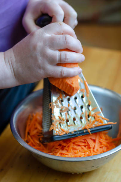 istock Woman grinds carrots on a grater. 1221533665