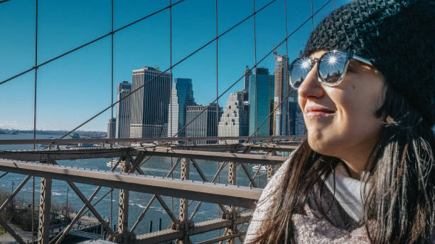 młoda piękna kobieta na brooklyn bridge nowy jork cieszy się wspaniałym słonecznym dniem - large transportation bridge famous place zdjęcia i obrazy z banku zdjęć