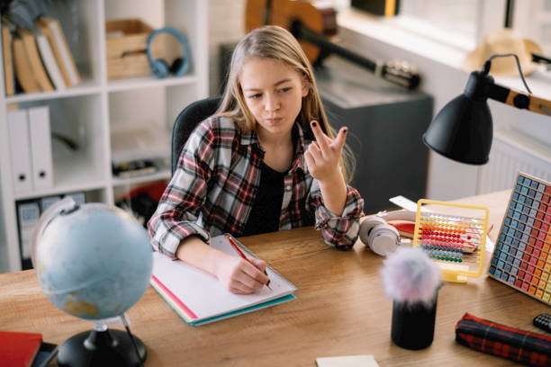 istock Beautiful little girl doing homework at home. 1221536943
