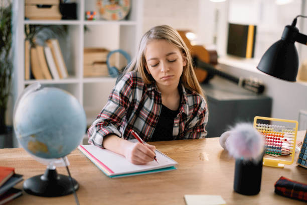 istock Beautiful little girl doing homework at home. 1221536997