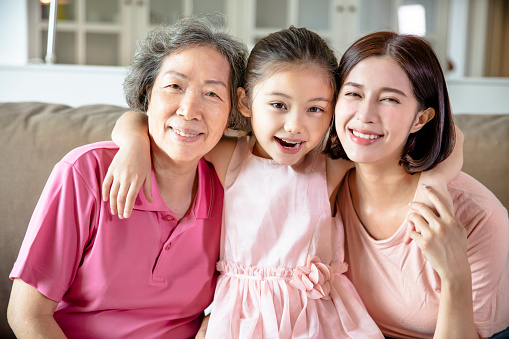 happy grandmother and daughter with granddaughter at home