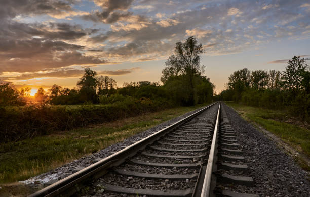 istock Train tracks in beautiful nature against a cloudy sunset sky 1221537102