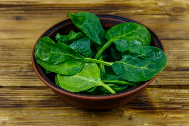 istock Fresh green spinach leaves in bowl on a wooden table 1221538865