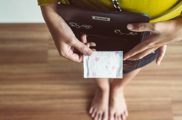 manos de mujer poniendo servilleta sanitaria en el bolso, almohadilla menstrual blanca, menstrua - hygienic pad fotografías e imágenes de stock