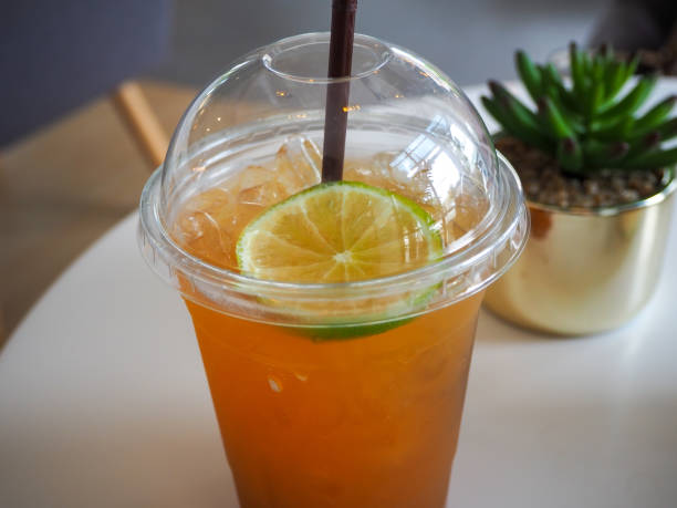 istock cold iced tea with lemon and straw in takeaway plastic cup. 1221541676