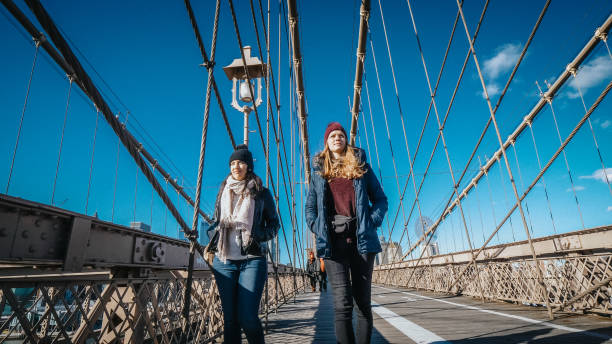 dwóch przyjaciół w nowym jorku spacer po słynnym brooklyn bridge - large transportation bridge famous place zdjęcia i obrazy z banku zdjęć