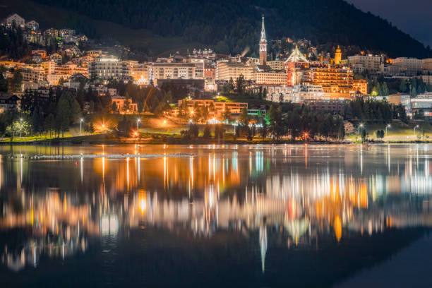 st moritz iluminado por la noche y refllection en el tranquilo lago, engadina – suiza - st moritz engadine landscape village fotografías e imágenes de stock