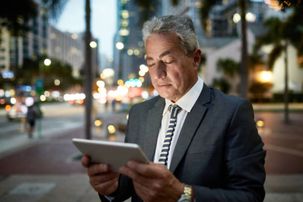 istock Senior Hispanic Businessman Using Digital Tablet Outdoors 1221545906
