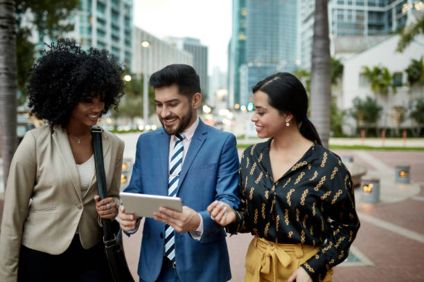 istock Hispanic Businessman Sharing Data on Tablet with Colleagues 1221545907